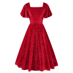 Détail d'une robe vintage en velours rouge avec pois argentés et manches à volants