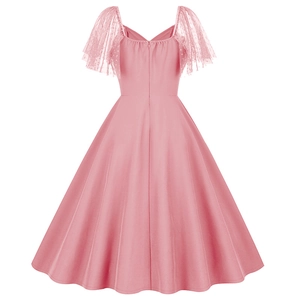 Detail of retro pink flared dress featuring polka dot mesh sleeves and sweetheart neckline