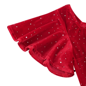 Détail de la robe en velours rouge avec pois argentés et élégantes manches à volants