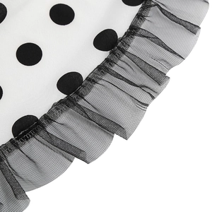 Detailed macro view of black polka dot fabric with pleated mesh ruffle hem finish