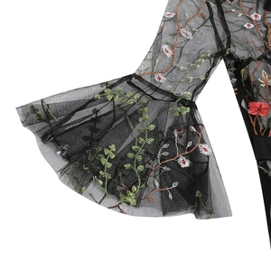 Close-up of floral embroidery on black mesh bell sleeves of a vintage gothic dress