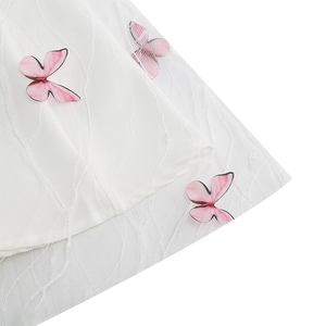 Detail of white mesh dress with wave embroidery and 3D pink butterfly appliques