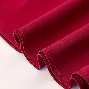 Detail of red fabric texture with professional double needle flat stitching on the hem