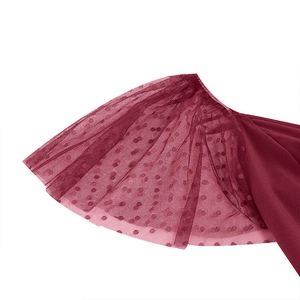 Detailed view of dark red mesh sleeves with velvet polka dots and ruffled edges