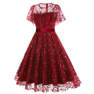 Detail of burgundy evening dress featuring sequin leaf embroidery and satin waist belt