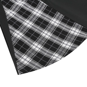 Close-up of contrast plaid stitching detail on the hem of a black French style dress