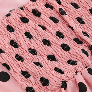 Macro shot of elastic shirring detail on a pink polka dot vintage lace dress