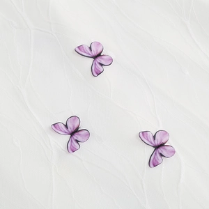 Detailed close-up of purple butterfly embroidery and lace texture on vintage dress