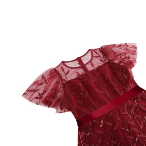 Detail of burgundy evening dress with mesh embroidery, sequins and satin waist belt