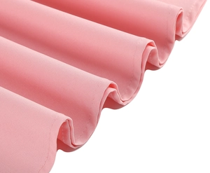 Detail of pink vintage dress showing fine fabric texture and wavy hemline craftsmanship