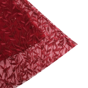 Detail of red mesh fabric with leaf embroidery and sequins for elegant evening dresses