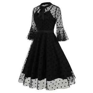 Detail of vintage black polka dot mesh dress with ribbon bow and flared sleeves