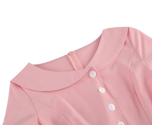 Detail of light pink dress featuring a Peter Pan collar and white button accents