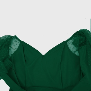 Detail of V-neckline and polka dot mesh sheer sleeves on a dark green retro dress