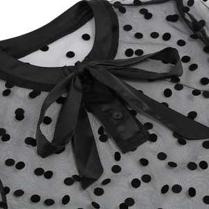 Close-up of black mesh fabric with velvet polka dots and elegant bow neck tie detail