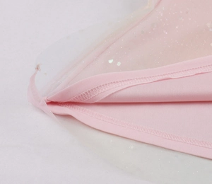 Close-up of pink tulle fabric with sparkling sequins and fine stitching on a party dress