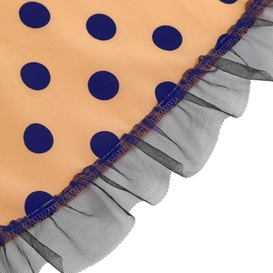 Detailed close-up of orange polka dot fabric with black lace mesh hem stitching