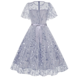Detailed back view of a lavender mesh dress with silver sequins and a large satin bow