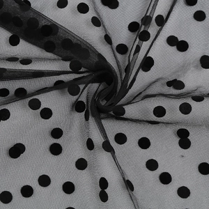 Close-up of black polka dot mesh fabric with flocked texture for vintage gothic dress