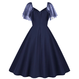 Detail view of navy blue A-line dress featuring polka dot mesh sleeves and back zipper