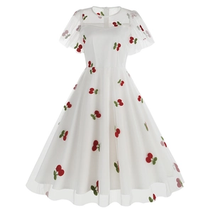 Vue détaillée d'une robe en maille blanche avec motifs cerises rouges et manches bouffantes