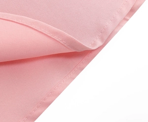 Detailed close-up of pink button-down dress fabric showing premium stitching and twill texture