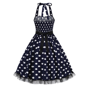 Detail of navy polka dot dress featuring elastic smocked back and black satin bow belt