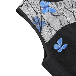 Detail of black lace dress featuring intricate blue butterfly embroidery and mesh texture