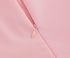 Close-up of pink dress detail showing a high-quality invisible zipper and woven fabric