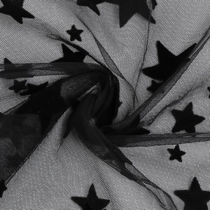 Close-up of black sheer mesh fabric with velvet flocked star patterns for gothic dress