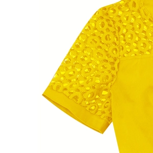 Detailed view of the yellow cocktail dress showing circular eyelet lace on the sleeve