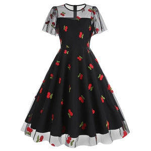 Détail de l'encolure en résille et de l'imprimé cerises sur cette robe rétro noire