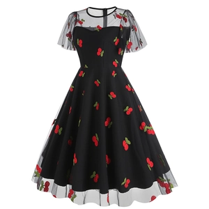 Détail d'une robe vintage en tulle noir avec broderie cerise et jupe évasée en coupe A-ligne