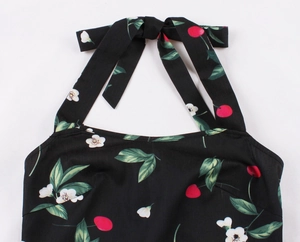 Dettaglio di un abito vintage a sottoveste con fiocco e stampa floreale di ciliegie