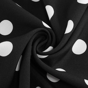 Macro shot of vintage black fabric with white polka dots and lace texture detail