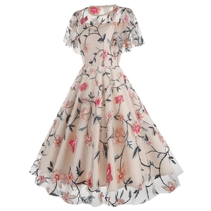 Detailed macro shot of elegant floral embroidery on apricot mesh vintage dress