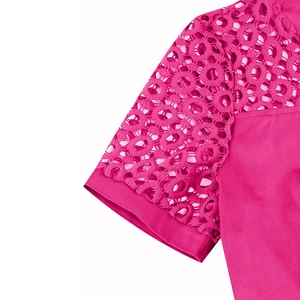 Detail of fuchsia cocktail dress featuring intricate circular hollow lace stitching on sleeves