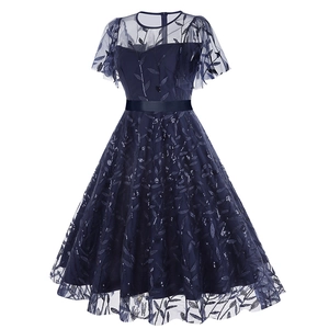 Close-up of navy blue cocktail dress with sequined leaf embroidery and mesh texture