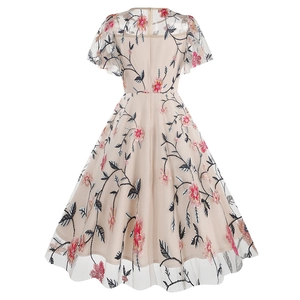 Detail of floral embroidery and invisible back zipper on a beige mesh A-line dress