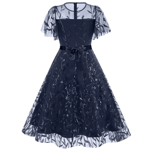 Detail of evening dress featuring mesh overlay with sequin leaves and satin bow tie