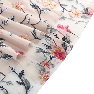 Detail of pink floral embroidery on white mesh overlay of a vintage dress