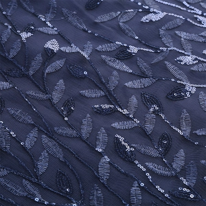 Detail of dark blue mesh tulle fabric featuring leaf embroidery and silver sequins