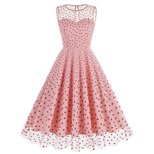 Détail d'une robe rétro rose des années 50 avec motifs cœurs et décolleté en tulle
