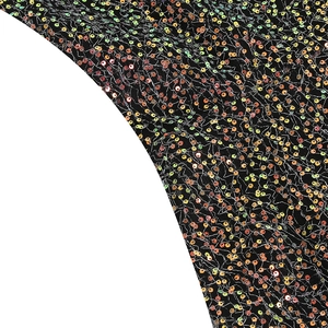 Detailaufnahme von schimmerndem schwarzem Paillettenstoff mit bunten holografischen Funken