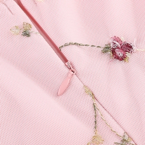 Détail de robe en tulle rose avec broderies florales et fermeture éclair invisible