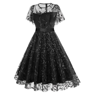 Detailed macro view of black mesh dress featuring leaf embroidery and shimmering sequins