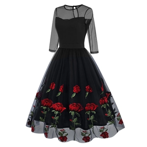 Detail de broderie rose rouge sur manche en tulle de robe noire retro style Hepburn