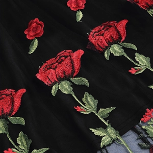 Gros plan détaillé de la broderie rose rouge sur un tissu en maille noire élégant