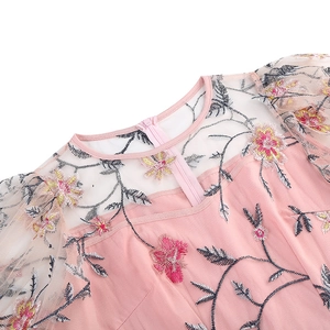 Close-up of pink dress with floral embroidery and sheer mesh on the neckline and back