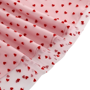 Détail du tissu en mesh rose avec motifs cœurs rouges pour robe rétro des années 50
